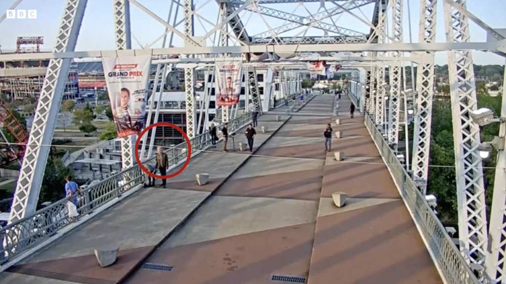 Jon Bon Jovi walking towards a woman standing on the ledge of John Seigenthaler Pedestrian Bridge